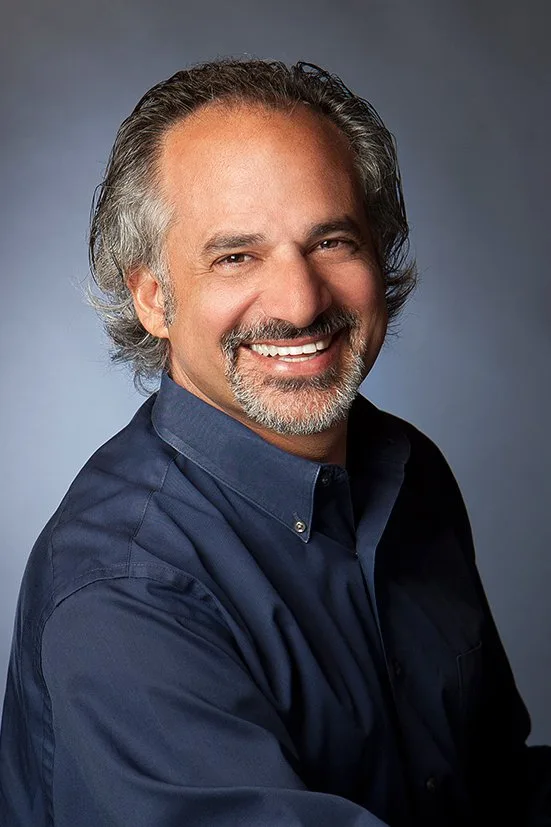 Approachable looking headshot of a man in blue.